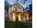 Charming two-story home with inviting front porch and manicured lawn at twilight at 619 S Gilpin St, Denver, CO 80209