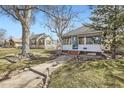 Charming single-story home with a blue door, landscaped front yard, and inviting walkway at 5668 S Foresthill St, Littleton, CO 80120