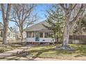 Charming single-story home with a blue door, mature trees, and a well-maintained front yard at 5668 S Foresthill St, Littleton, CO 80120