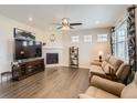 Comfortable living room with fireplace, abundant natural light, and hardwood flooring at 8953 Falcon St, Firestone, CO 80504