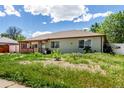 Well-maintained single-story house with a cozy front porch and easy to care for landscaping and blue skies at 1151 Revere St, Aurora, CO 80011