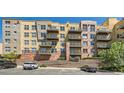A full, low-angle exterior view of a condominium complex with multi-level balconies, brick accents, and parking at 9079 E Panorama Cir # 419, Englewood, CO 80112