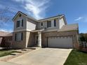 Attractive two-story home with tan brick, gray siding, and a two car garage at 1160 S Fultondale Ct, Aurora, CO 80018