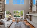 Bright living room with a stone fireplace, soaring windows, and a neutral color palette creating a welcoming atmosphere at 6995 S Ensenada St, Aurora, CO 80016