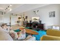 Comfortable living room with stylish furniture, a bright blue rug, and a modern entertainment center at 1255 N Ogden St # 605, Denver, CO 80218