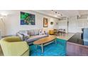 Inviting living room featuring a gray sofa, contemporary art, and a glimpse of the dining area at 1255 N Ogden St # 605, Denver, CO 80218