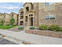 Apartment building exterior with stone accents, well-maintained landscaping, and visible unit numbers at 17442 Nature Walk Trl # 105, Parker, CO 80134