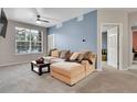 Comfortable living room with neutral carpet, a large sectional sofa, and a bright window at 17442 Nature Walk Trl # 105, Parker, CO 80134