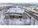 Aerial view of snow-covered home with surrounding neighborhood and mountains in the distance at 5906 S Youngfield Way, Littleton, CO 80127