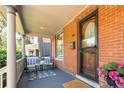 Inviting front porch featuring brick facade, sitting area and space for outdoor enjoyment at 669 S Washington St, Denver, CO 80209