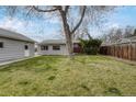 Spacious backyard featuring a well-maintained lawn, fence, and detached garage at 6895 W Oregon Dr, Lakewood, CO 80232