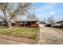 Inviting single-story home featuring a well maintained front yard, brick accents, long driveway and detached garage at 6895 W Oregon Dr, Lakewood, CO 80232