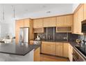 Modern kitchen with stainless steel appliances, wooden cabinets and view into the living space at 340 S Lafayette St # 201, Denver, CO 80209