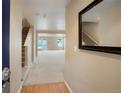 Bright foyer with wood floors, carpeted stairs, and neutral walls leading to a spacious living area at 19029 E 58Th Ave, Denver, CO 80249
