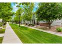 Landscaped street view featuring a row of townhouses, lush greenery, and well-maintained lawns at 19029 E 58Th Ave, Denver, CO 80249
