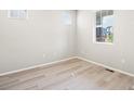 Bright bedroom with wood look floors, white walls, and multiple windows at 379 Remuda Rd, Berthoud, CO 80513