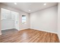 Bright, modern living room with wood floors, a window view, and a staircase at 1699 Morgan Dr, Erie, CO 80516