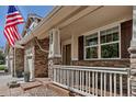 Inviting front porch with white railing, stone accents, and an American flag at 6345 S Ider Way, Aurora, CO 80016