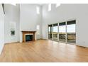 Spacious living room with a fireplace, high ceilings, and a sliding glass door to a deck at 9322 Quaker St, Arvada, CO 80007