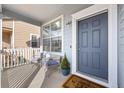 Inviting front porch features seating, a welcome mat, and a blue front door at 12366 Nate Cir, Parker, CO 80134
