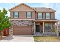 Two-story home with stone accents, shutters, covered porch and attached two car garage at 467 S 36Th Ave, Brighton, CO 80601