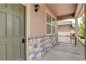 Covered front porch with stone base, siding, and view of the neighboring home at 467 S 36Th Ave, Brighton, CO 80601