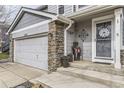 Charming entrance with decorative accents, stone pillar and gray siding details at 11746 Elizabeth Cir, Thornton, CO 80233