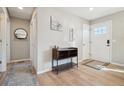Inviting entryway with sleek wood floors, white walls, a small wooden console table, and front door at 6393 S Johnson St, Littleton, CO 80123