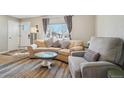 Cozy living room with a large picture window, plush seating, and neutral decor at 6393 S Johnson St, Littleton, CO 80123
