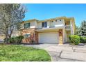 Charming two-story home featuring a two-car garage, stone facade, and manicured lawn at 1311 S Kingston St, Aurora, CO 80012