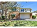Two-story house featuring a two-car garage, stone facade, and well-maintained green lawn at 1311 S Kingston St, Aurora, CO 80012