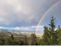Wide landscape view featuring a double rainbow arching over a lush, green valley and mountains at 33090 Janelle Cir, Golden, CO 80403