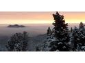 Scenic mountain view with snow-covered trees and a stunning sunrise in the background at 33090 Janelle Cir, Golden, CO 80403