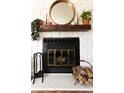 Close-up of brick fireplace featuring a wood mantel, decorative mirror, and hearth at 19738 Applewood Ct, Parker, CO 80138