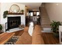 Bright living room boasts hardwood floors, a brick fireplace, and staircase access at 19738 Applewood Ct, Parker, CO 80138