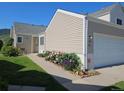 Home exterior featuring a two-car garage, vibrant flower bed, and well-kept lawn at 535 High Point Dr, Golden, CO 80403
