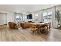 Bright open-concept living area with wood floors, comfortable seating, and a large dining table at 8733 Arriba Dr, Littleton, CO 80125