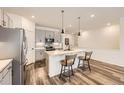 Modern kitchen featuring an island with seating, pendant lighting, and stainless steel appliances at 15376 Ivanhoe Ct, Thornton, CO 80602