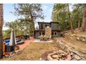 Backyard deck with outdoor seating, fire pit, stone chimney, and mountain views at 4986 White House Trl, Evergreen, CO 80439