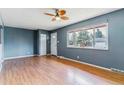 Spacious living room with hardwood floors, large windows, and a ceiling fan at 16588 E 8Th Ave, Aurora, CO 80011