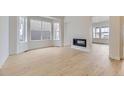 Bright living room with hardwood floors, a modern fireplace, and expansive windows offer plenty of natural light at 3877 Treadway Pt, Castle Rock, CO 80108