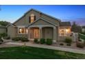 Inviting home features a covered porch, stone accents, and manicured front lawn at 6033 Trailhead Rd, Highlands Ranch, CO 80130