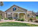 Exterior view of home with covered porch, stone details, and tidy landscaping at 6033 Trailhead Rd, Highlands Ranch, CO 80130