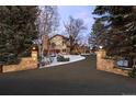 A long driveway leads up to a beautiful house, framed by stone pillars at 50 Meade Ln, Cherry Hills Village, CO 80113