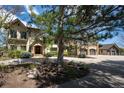 Beautiful home with a manicured lawn, mature trees, and a circular driveway providing curb appeal at 50 Meade Ln, Cherry Hills Village, CO 80113