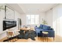 Comfortable living room featuring a plush blue sofa, a modern fireplace, and large windows for natural light at 1822 Grove St # 110, Denver, CO 80204