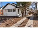 Charming exterior view of the home with painted white brick and tidy yard with an inviting walkway at 1858 S Lincoln St, Denver, CO 80210
