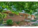 Charming brick home with front yard landscaping and warm interior lighting glowing through the windows at 2698 S Niagara St, Denver, CO 80224