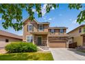 Inviting home exterior featuring a covered front porch, stone accents, and a lush green lawn at 16643 E 101St Ave, Commerce City, CO 80022