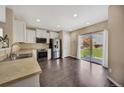Open kitchen featuring stainless steel appliances, light countertops, and a sliding glass door to the backyard at 16643 E 101St Ave, Commerce City, CO 80022